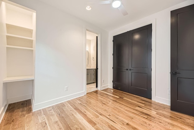 unfurnished bedroom featuring connected bathroom, a closet, light hardwood / wood-style flooring, and ceiling fan