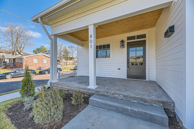 view of exterior entry featuring covered porch