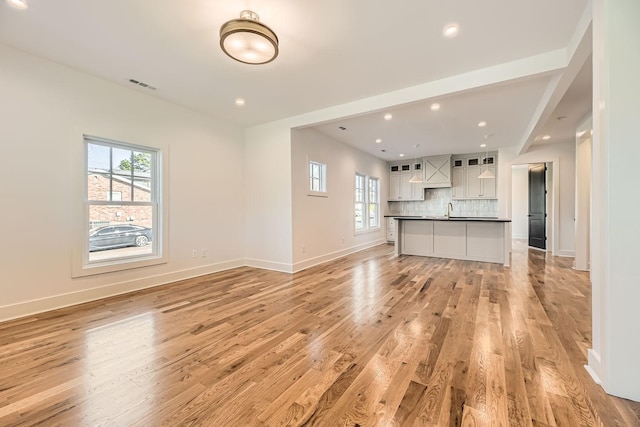 unfurnished living room featuring light hardwood / wood-style floors and sink