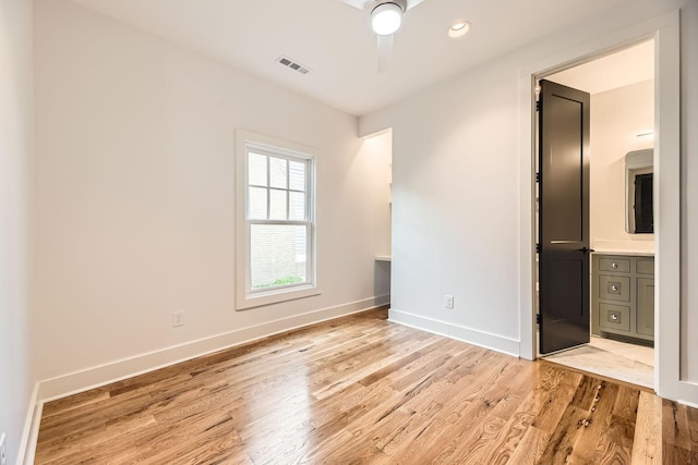 unfurnished bedroom featuring ceiling fan, ensuite bathroom, and light hardwood / wood-style floors