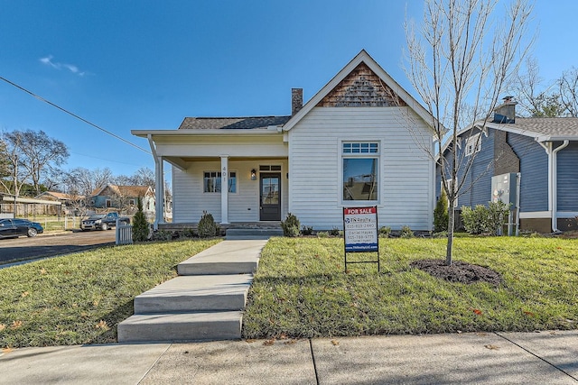 bungalow-style house with covered porch and a front yard