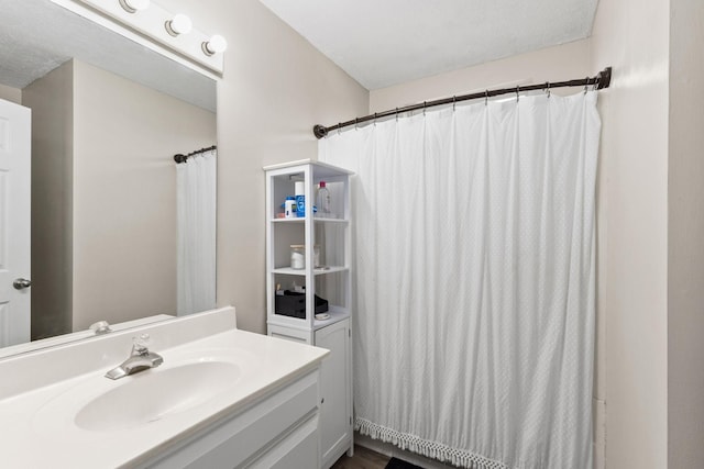 bathroom featuring curtained shower, vanity, a textured ceiling, and hardwood / wood-style flooring