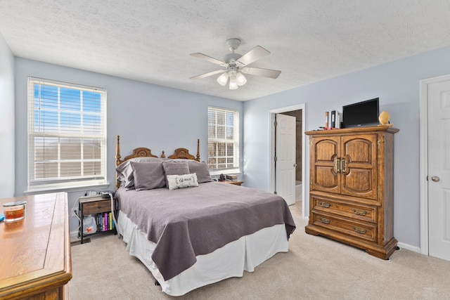 carpeted bedroom featuring ceiling fan, a textured ceiling, and connected bathroom