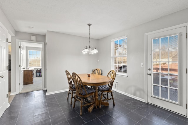 dining space featuring a notable chandelier, plenty of natural light, and a textured ceiling