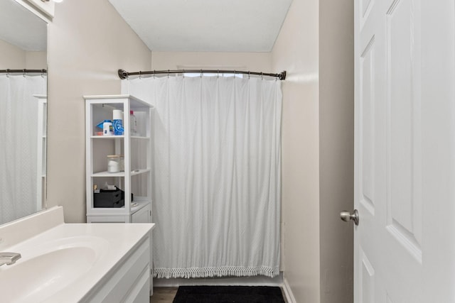 bathroom featuring hardwood / wood-style flooring, vanity, and curtained shower