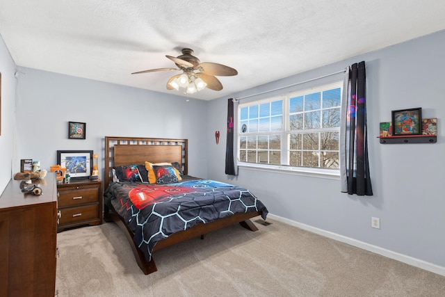 carpeted bedroom featuring ceiling fan and a textured ceiling