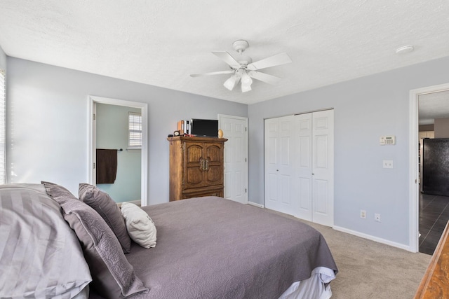 carpeted bedroom featuring ceiling fan, a textured ceiling, and a closet