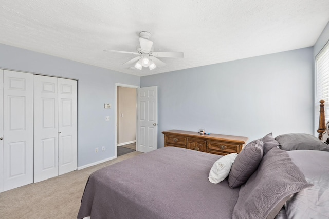 carpeted bedroom featuring ceiling fan, a closet, and a textured ceiling