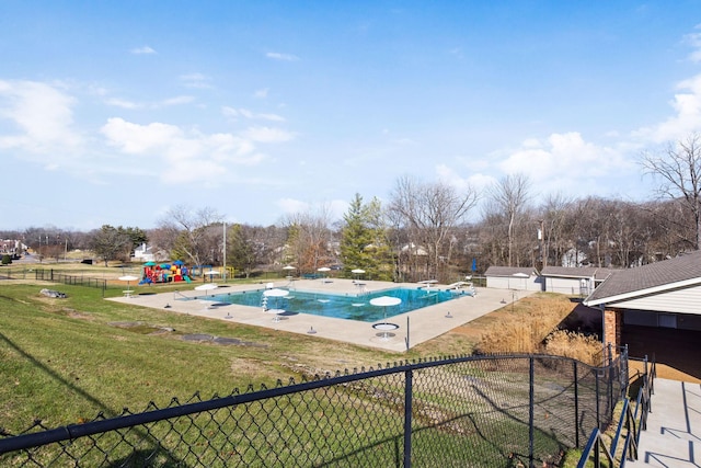 view of swimming pool with a lawn, a diving board, a patio area, and a playground