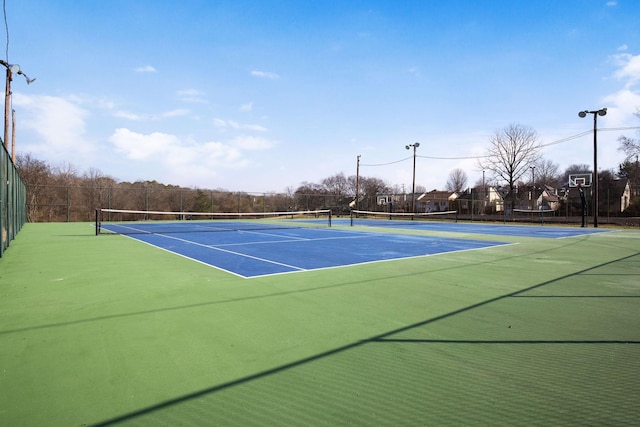 view of tennis court featuring basketball hoop