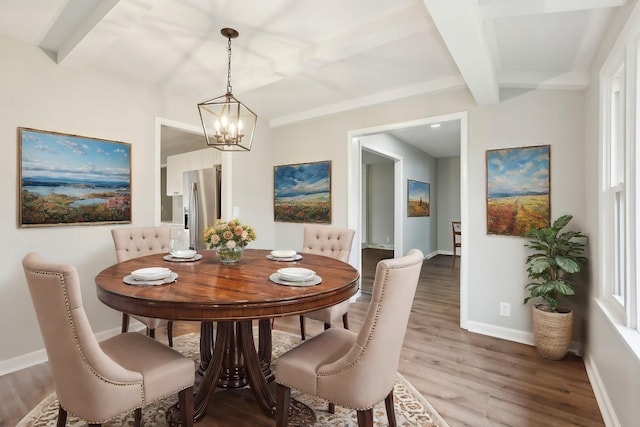 dining room with a chandelier, beam ceiling, baseboards, and wood finished floors