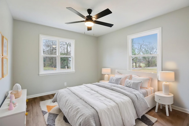 bedroom with ceiling fan, baseboards, and wood finished floors