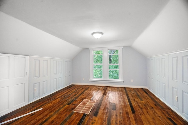 bonus room with dark hardwood / wood-style floors and vaulted ceiling