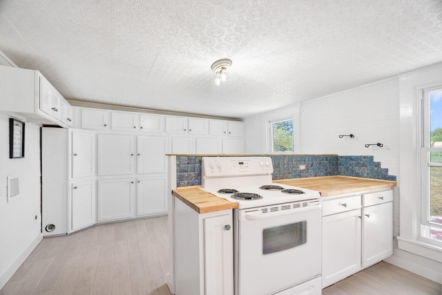 kitchen with white cabinets, butcher block countertops, white range with electric cooktop, and tasteful backsplash