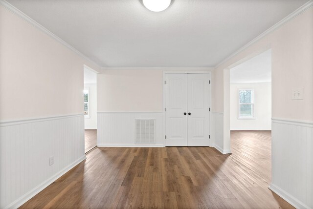 unfurnished room featuring wood-type flooring and crown molding