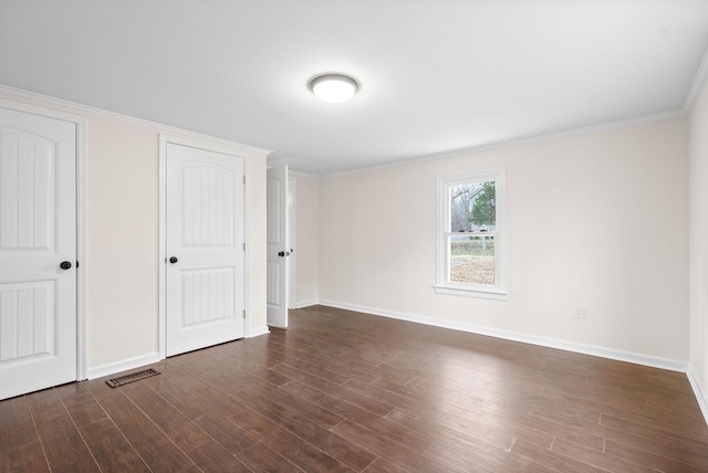 unfurnished bedroom featuring crown molding and dark hardwood / wood-style flooring