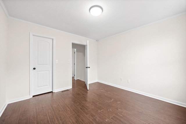 unfurnished bedroom featuring crown molding and dark wood-type flooring