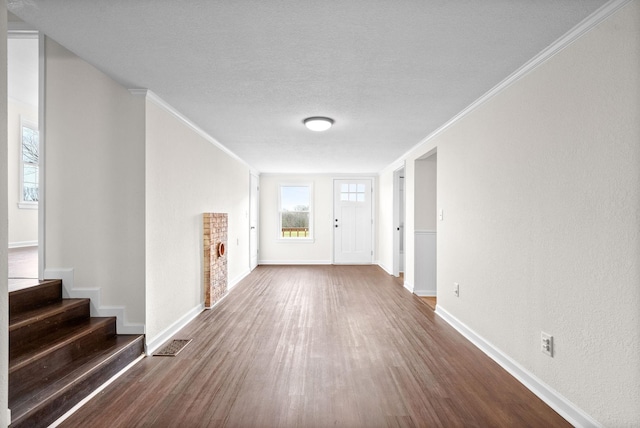 foyer with dark hardwood / wood-style flooring, ornamental molding, and a fireplace