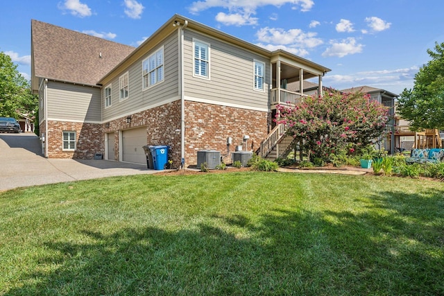 view of home's exterior featuring a lawn, cooling unit, a garage, and a balcony