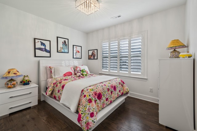 bedroom with dark wood-type flooring and an inviting chandelier