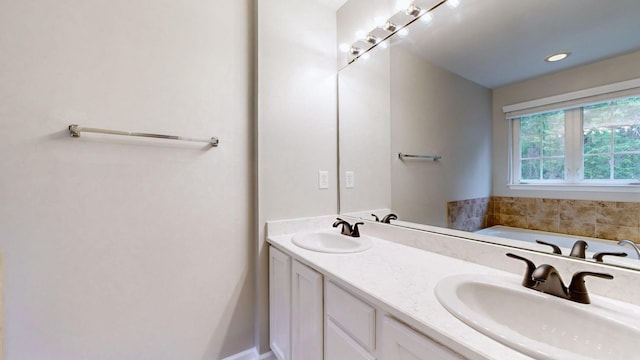 bathroom with a tub to relax in and vanity