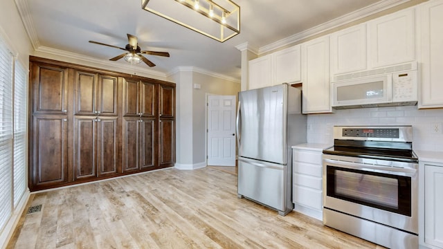 kitchen with ceiling fan, a healthy amount of sunlight, tasteful backsplash, crown molding, and appliances with stainless steel finishes