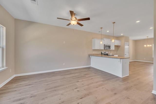 kitchen with pendant lighting, white cabinetry, kitchen peninsula, and stainless steel appliances