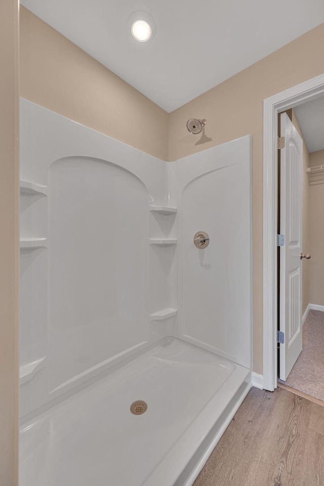 bathroom with hardwood / wood-style floors and a shower