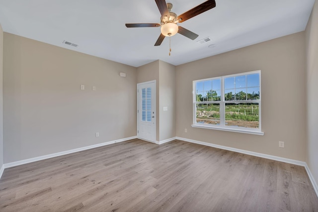 spare room with light wood-type flooring and ceiling fan