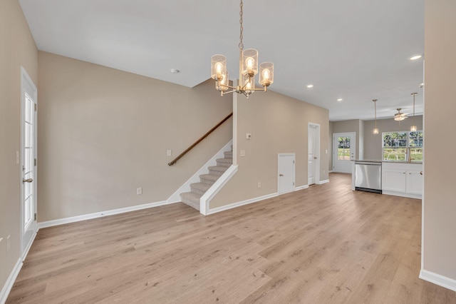 unfurnished living room featuring light hardwood / wood-style floors and ceiling fan with notable chandelier