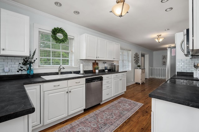 kitchen featuring white cabinets, appliances with stainless steel finishes, dark wood-type flooring, and sink