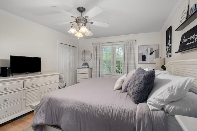 bedroom featuring ceiling fan, light hardwood / wood-style flooring, crown molding, and a closet