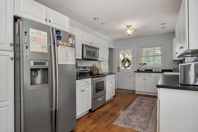 kitchen featuring tasteful backsplash, white cabinetry, stainless steel appliances, and dark hardwood / wood-style floors