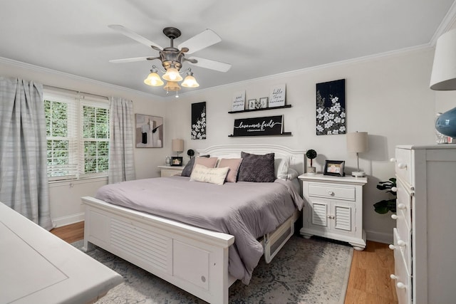 bedroom with ceiling fan, wood-type flooring, and ornamental molding