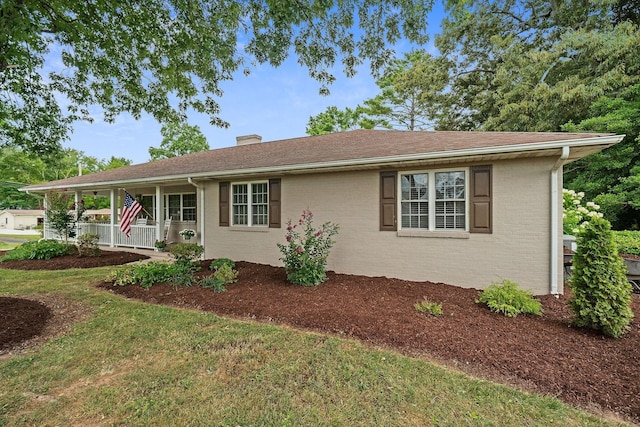 single story home with a porch and a front lawn