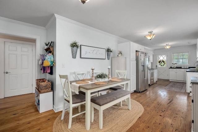 dining room featuring ornamental molding and light wood-type flooring