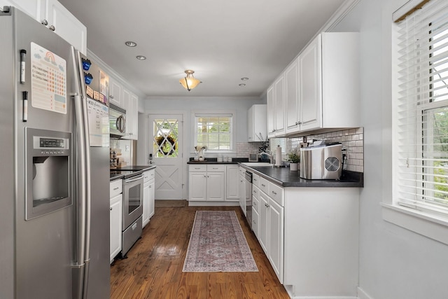 kitchen with white cabinetry, sink, stainless steel appliances, dark hardwood / wood-style flooring, and decorative backsplash