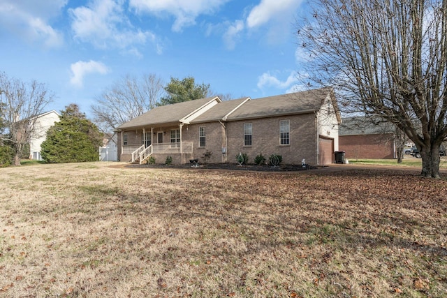 back of house with a lawn, covered porch, and a garage