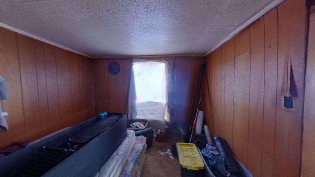 misc room with a textured ceiling and wooden walls