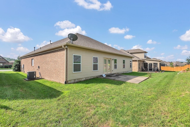 back of house featuring a lawn, cooling unit, and a patio