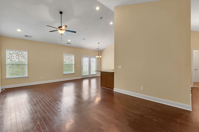 spare room featuring ceiling fan with notable chandelier, dark hardwood / wood-style flooring, and high vaulted ceiling