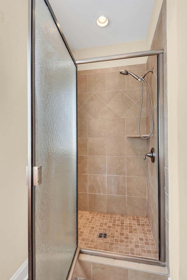 bathroom featuring a shower with door