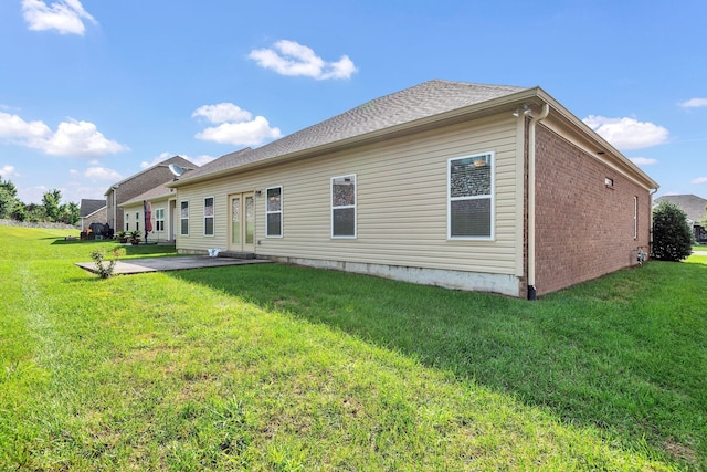 back of property featuring a yard and a patio