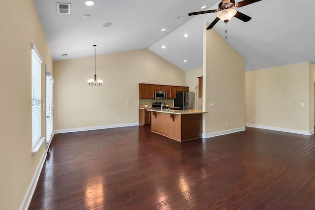 unfurnished living room with ceiling fan with notable chandelier, dark hardwood / wood-style floors, and high vaulted ceiling