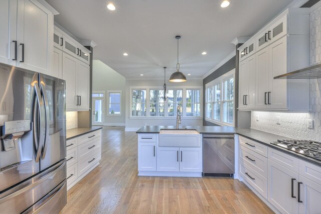 kitchen with pendant lighting, backsplash, sink, appliances with stainless steel finishes, and white cabinetry