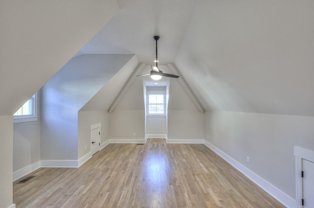 additional living space featuring plenty of natural light, light hardwood / wood-style floors, ceiling fan, and vaulted ceiling