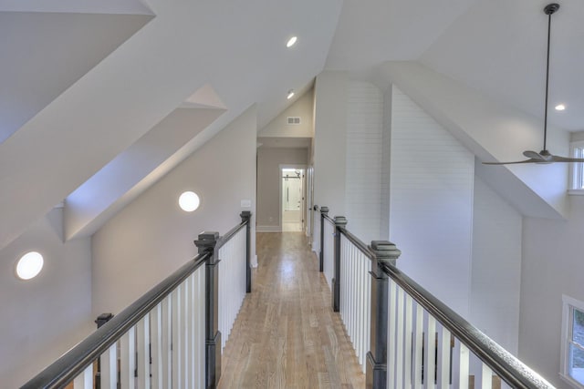 hall with light hardwood / wood-style floors and vaulted ceiling