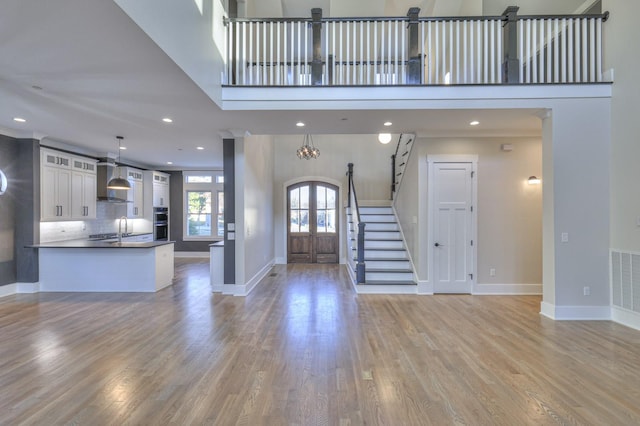 foyer with a chandelier, light hardwood / wood-style floors, sink, and french doors