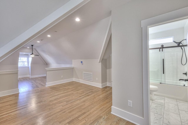 bonus room featuring light hardwood / wood-style flooring, vaulted ceiling, and ceiling fan