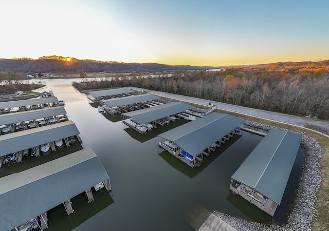 aerial view at dusk featuring a water view